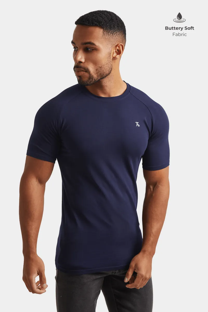 Model in a navy athletic fit t-shirt and stone pants