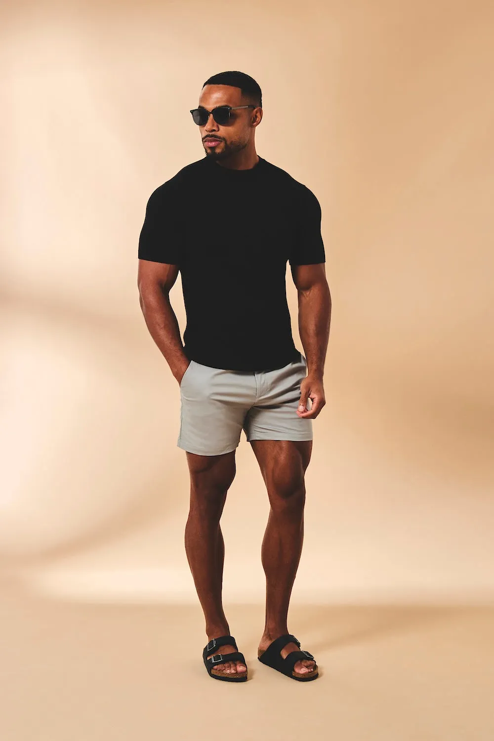 Model in a black t-shirt and pale grey shorts
